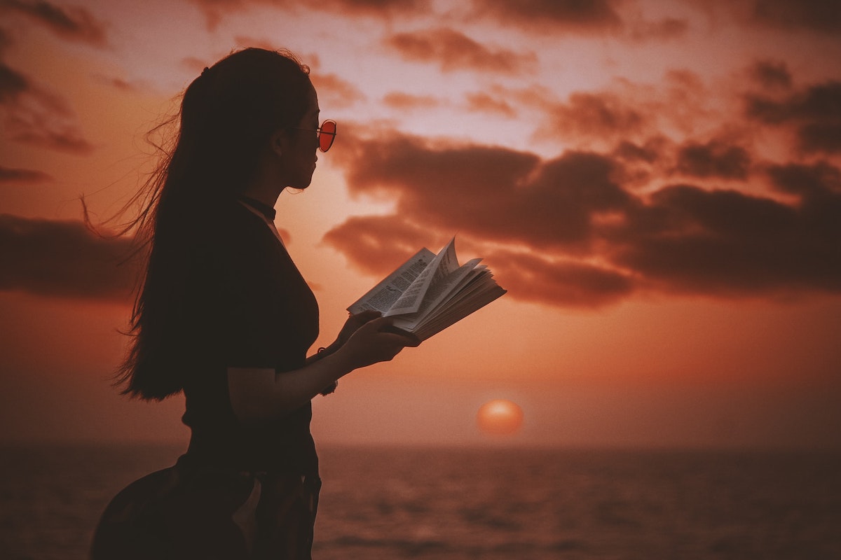 海辺で本を読む女性